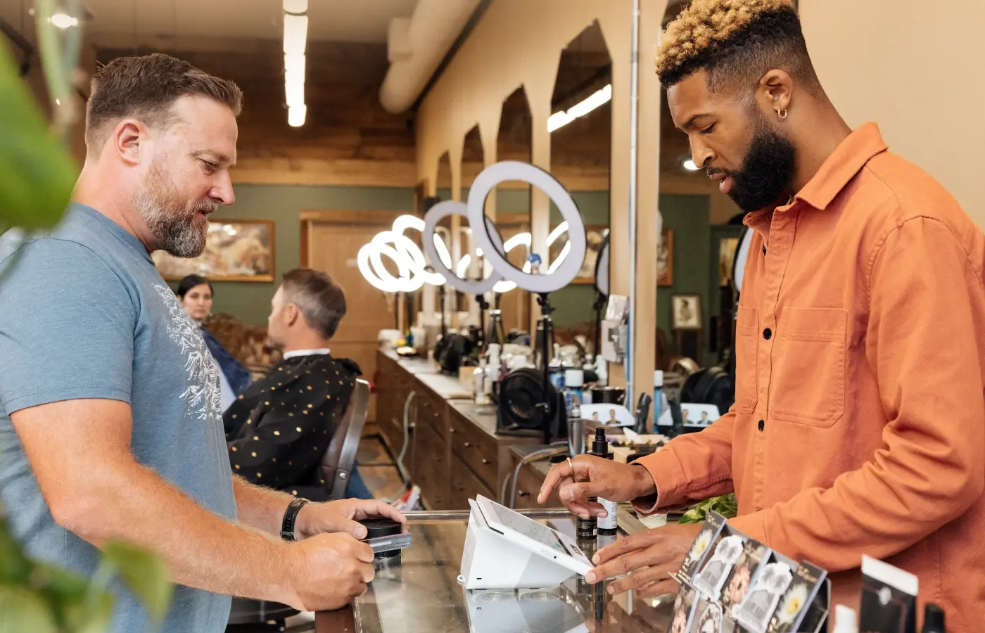 Barbershop customer paying at the counter