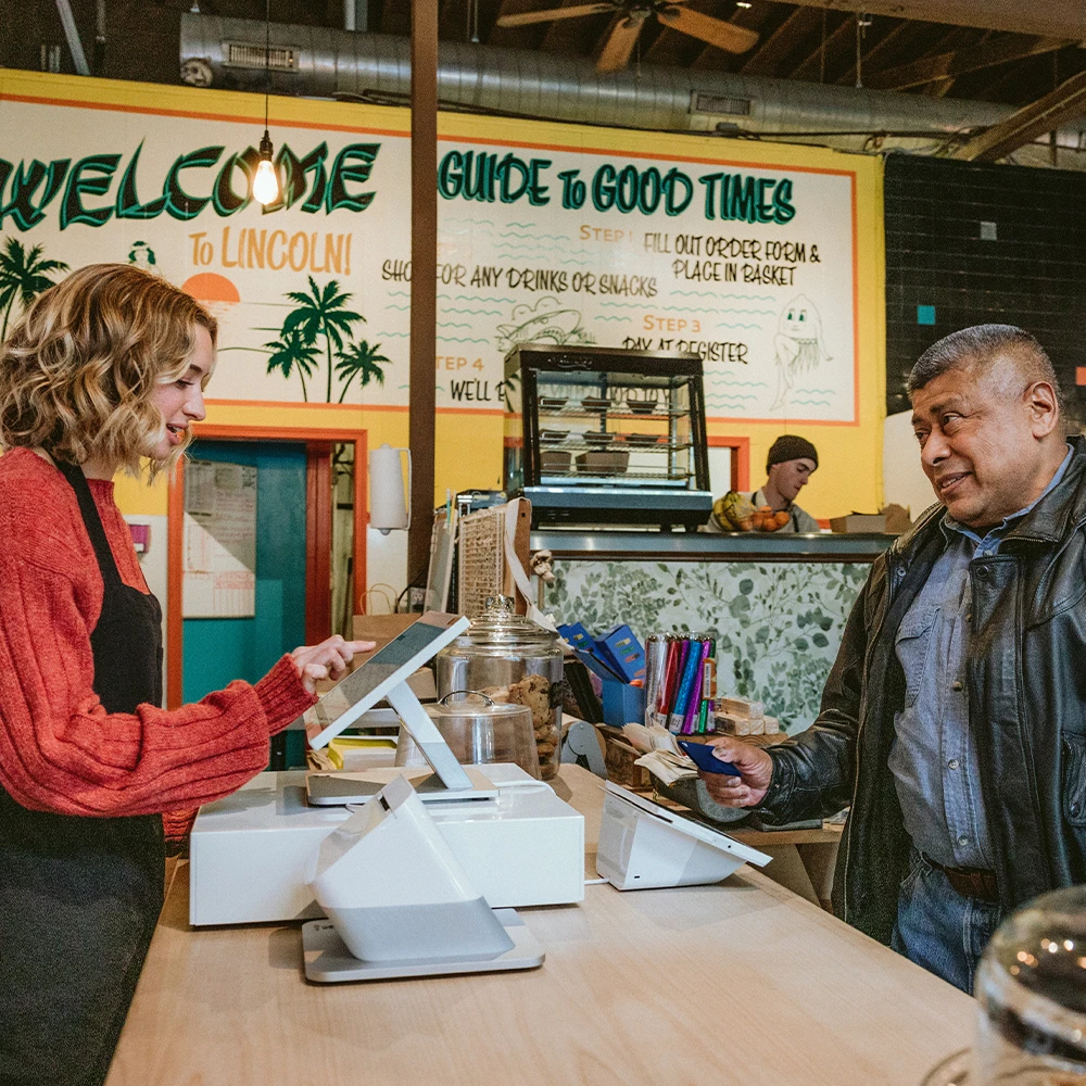 Customer paying at a cafe counter with cashier.